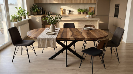 Round solid oak extendable kitchen table with black metal base in a bright modern dining area