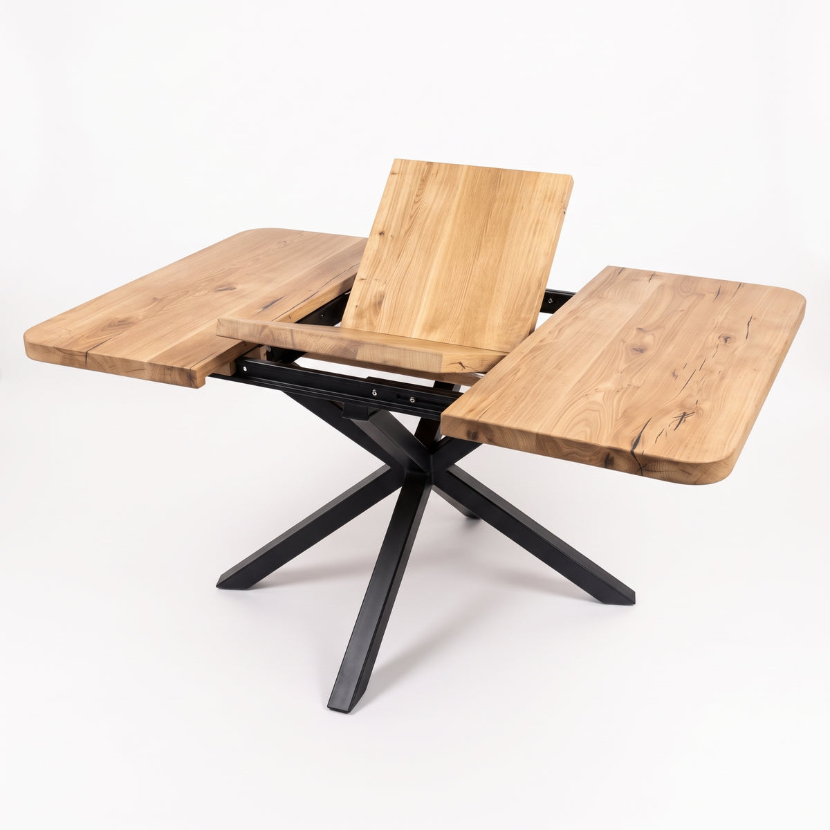 A modern outdoor dining table with a natural wood finish and a black metal X-frame base, shown with its center panel raised and side wings extended on a white background.