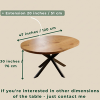 A wooden dining table with a round light oak top and black X-shaped legs on a beige background, overlaid with dimension arrows and text showing 47 inches by 30 inches and an extension of 20 inches.